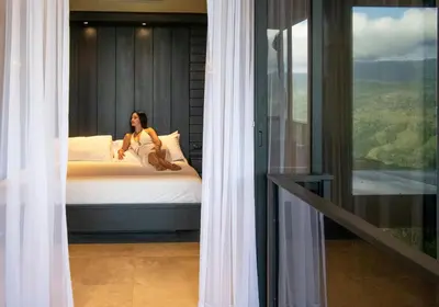 a woman sitting on a bed in a room at Odyssey Villa, 3 bedrooms with Pool! in San Luis