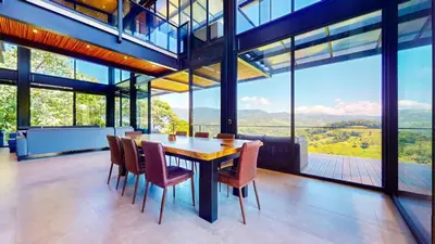 a dining room with a table and chairs and windows at Odyssey Villa, 3 bedrooms with Pool! in San Luis