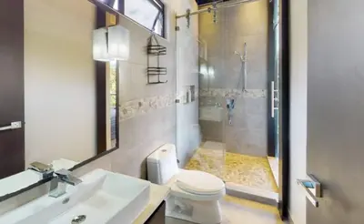 a bathroom with a shower and a toilet and a sink at Odyssey Villa, 3 bedrooms with Pool! in San Luis