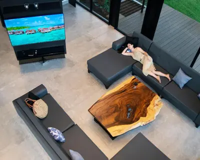 a woman laying on a couch with a wooden table at Odyssey Villa, 3 bedrooms with Pool! in San Luis