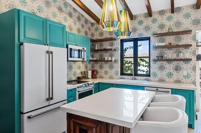 a kitchen with green cabinets and a white refrigerator at Trendy Condo with Stunning Ocean Views and Exclusive Beach Club Access in Las Catalinas in Playa Danta