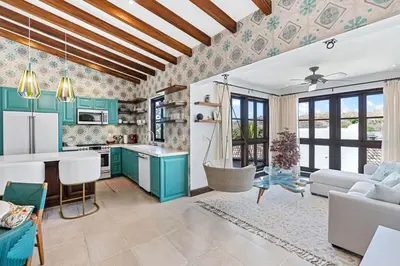 a kitchen with blue cabinets and a living room at Trendy Condo with Stunning Ocean Views and Exclusive Beach Club Access in Las Catalinas in Playa Danta
