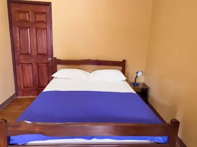 a bedroom with a bed with a blue blanket at Belen Suites in San Antonio