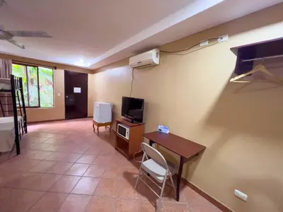 a living room with a desk and a tv and a table at Belen Suites in San Antonio