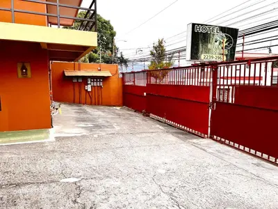 a red building with a sign on the side of it at Belen Suites in San Antonio