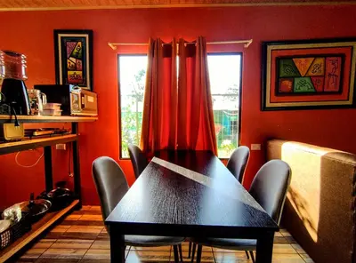 a dining room with a table and chairs and a window at Cabinas Río Frío in San Rafael
