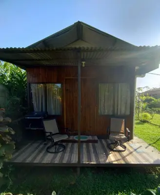 a gazebo with two chairs and a piano on a deck at Cabinas Río Frío in San Rafael