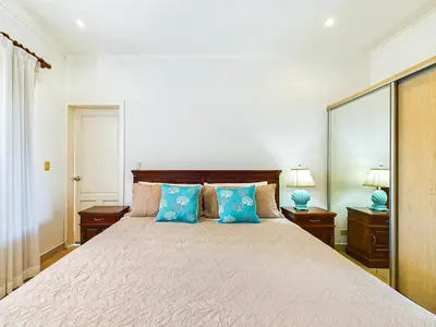 a bedroom with a large bed with blue pillows at Sunrise 4-Beautiful 3Br Penthouse Condo in Tamarindo
