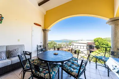 a patio with a table and chairs on a balcony at Sunrise 4-Beautiful 3Br Penthouse Condo in Tamarindo