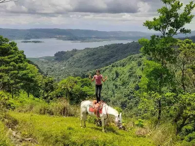 a woman standing on top of a white horse on a hill at Finca Del Cielo in El Castillo de la Fortuna