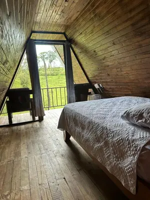 a bedroom with a bed and a large window at Bungalow Tenorio Mountain Lodge in Rio Celeste