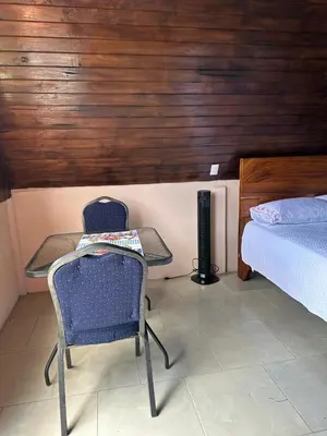 a bedroom with a table and a chair and a bed at Bungalow Tenorio Mountain Lodge in Rio Celeste