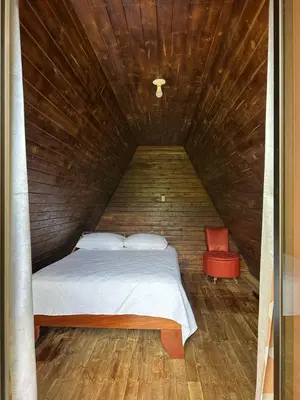 a bed in a small room with a wooden ceiling at Bungalow Tenorio Mountain Lodge in Rio Celeste