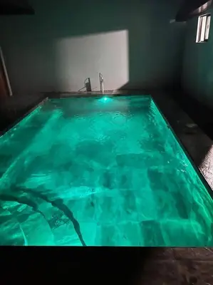 a swimming pool with green water in a room at Casas Plamont in Fortuna