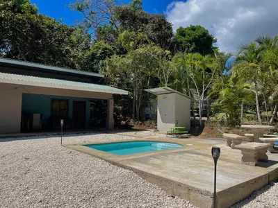 a house with a small swimming pool in the yard at Casa Encanto in Puntarenas