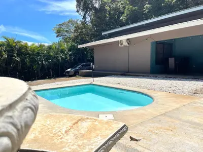 a swimming pool in a yard next to a house at Casa Encanto in Puntarenas