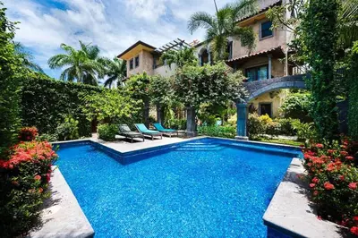 a swimming pool in front of a house at Sunset & OceanView Terrace, Pool, Beach and Grill in Tamarindo