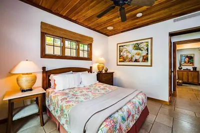 a bedroom with a bed and a table with a lamp at Sunset & OceanView Terrace, Pool, Beach and Grill in Tamarindo