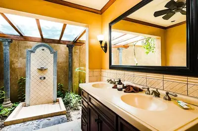 a bathroom with a sink and a large mirror at Sunset & OceanView Terrace, Pool, Beach and Grill in Tamarindo