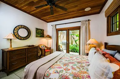 a bedroom with a bed and a ceiling fan at Sunset & OceanView Terrace, Pool, Beach and Grill in Tamarindo