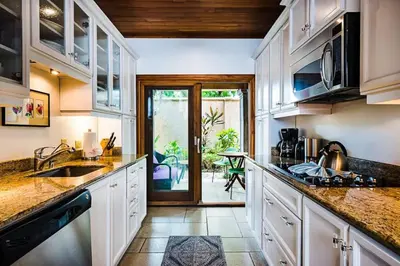 a kitchen with white cabinets and a counter top at Sunset & OceanView Terrace, Pool, Beach and Grill in Tamarindo