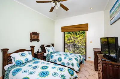 a bedroom with two beds and a flat screen tv at Family Setting, Big Pool Beach facing in towns in Tamarindo