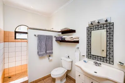 a bathroom with a toilet and a sink and a mirror at Family Setting, Big Pool Beach facing in towns in Tamarindo