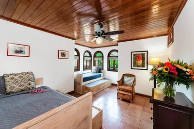 a bedroom with a bed and a couch at Private Pool, 3bd Villa near the Beach in Tamarindo