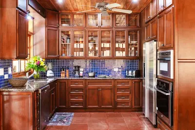 a kitchen with wooden cabinets and a ceiling fan at Private Pool, 3bd Villa near the Beach in Tamarindo