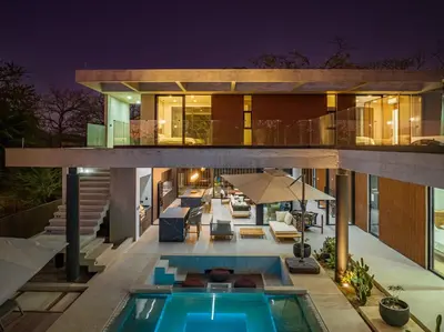 a house with a swimming pool at night at New 6 bd Modern Home Walk to Beach in Tamarindo