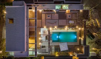an aerial view of a building with a pool at night at New 6 bd Modern Home Walk to Beach in Tamarindo