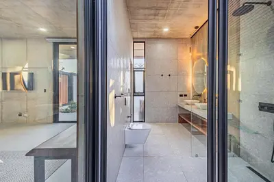 a bathroom with a toilet and a glass door at New 6 bd Modern Home Walk to Beach in Tamarindo