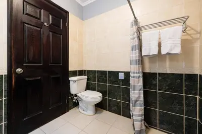 a bathroom with a toilet and a shower at Pool and Private rooftop access in town! in Tamarindo