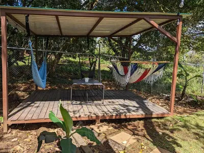 a pergola with a table and hammocks on a deck at Yellow House - Country house near La Fortuna in San Ramón