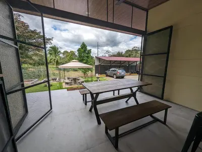 a patio with a picnic table and a view of a parking lot at Yellow House - Country house near La Fortuna in San Ramón