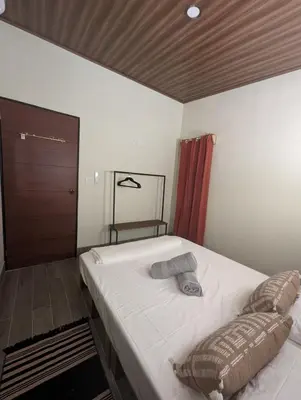 a bedroom with a large bed with a wooden ceiling at Yellow House - Country house near La Fortuna in San Ramón