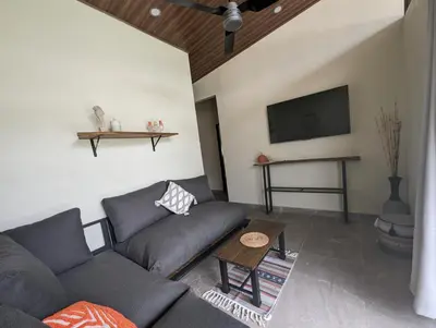a living room with a couch and a tv at Yellow House - Country house near La Fortuna in San Ramón