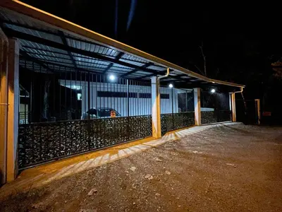 a fence in front of a building at night at Casa Tucan in Quepos