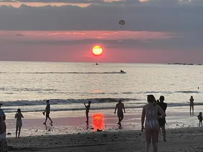 a group of people playing on the beach at sunset at Casa Tucan in Quepos