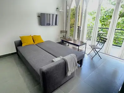 a bedroom with a bed with yellow pillows and a table at Casa Tucan in Quepos