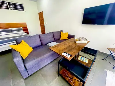 a living room with a purple couch with yellow pillows at Casa Tucan in Quepos