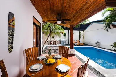 a dining room with a table and a swimming pool at Remodeled Casa Tropical w Private Pool in Tamarindo