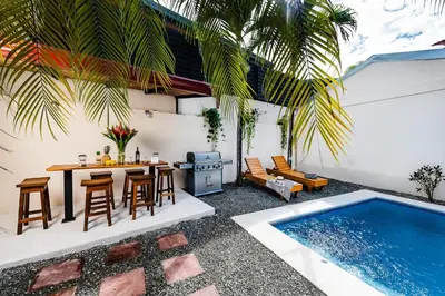 a patio with a table and chairs next to a swimming pool at Remodeled Casa Tropical w Private Pool in Tamarindo