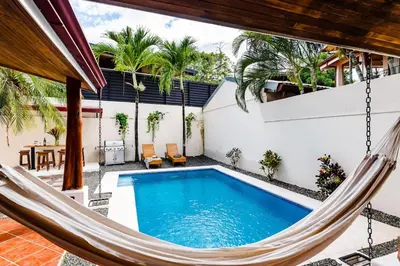 a patio with a hammock and a swimming pool at Remodeled Casa Tropical w Private Pool in Tamarindo