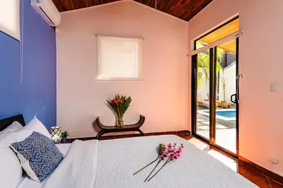 a bedroom with a bed with flowers on it at Remodeled Casa Tropical w Private Pool in Tamarindo