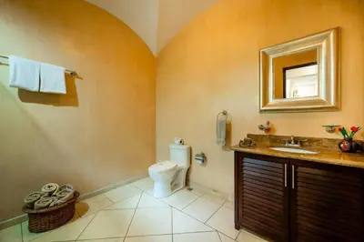 a bathroom with a toilet and a sink and a mirror at Oceanview Escape Large Pool and 247 Security! in Tamarindo