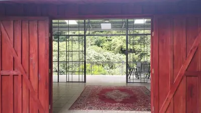 an open room with a red door with a table and a rug at Maison tranquille in Rivas