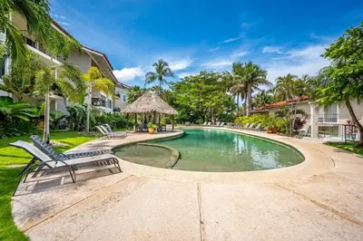 a swimming pool in the middle of a yard at Beautiful beachfront 2BR condo, with full kitchen in Tamarindo