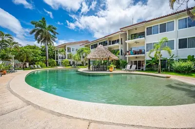 a swimming pool in front of a building at Beautiful beachfront 2BR condo, with full kitchen in Tamarindo
