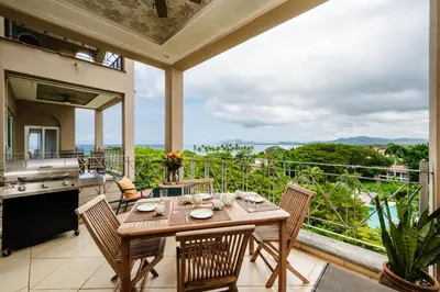 a patio with a table and chairs on a balcony at Oceanview in town Huge Pool Beach acss in Tamarindo